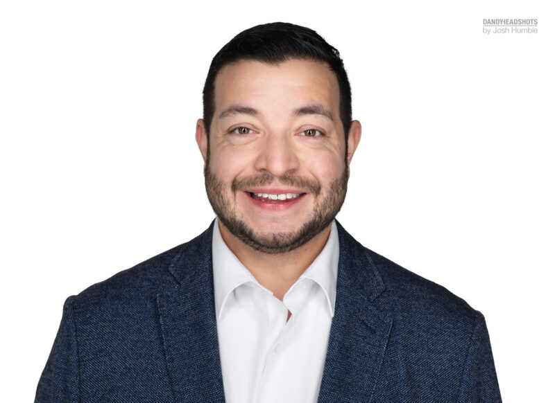 Professional headshot of male, white background, high-key.